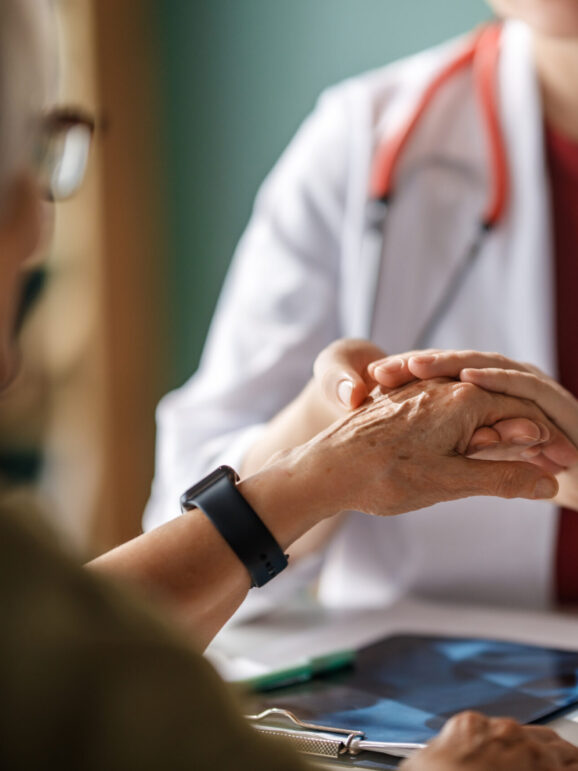Colour ribbon for concept of illness awareness. Female patient listening to doctor in medical office. Raising knowledge on people living with disease.